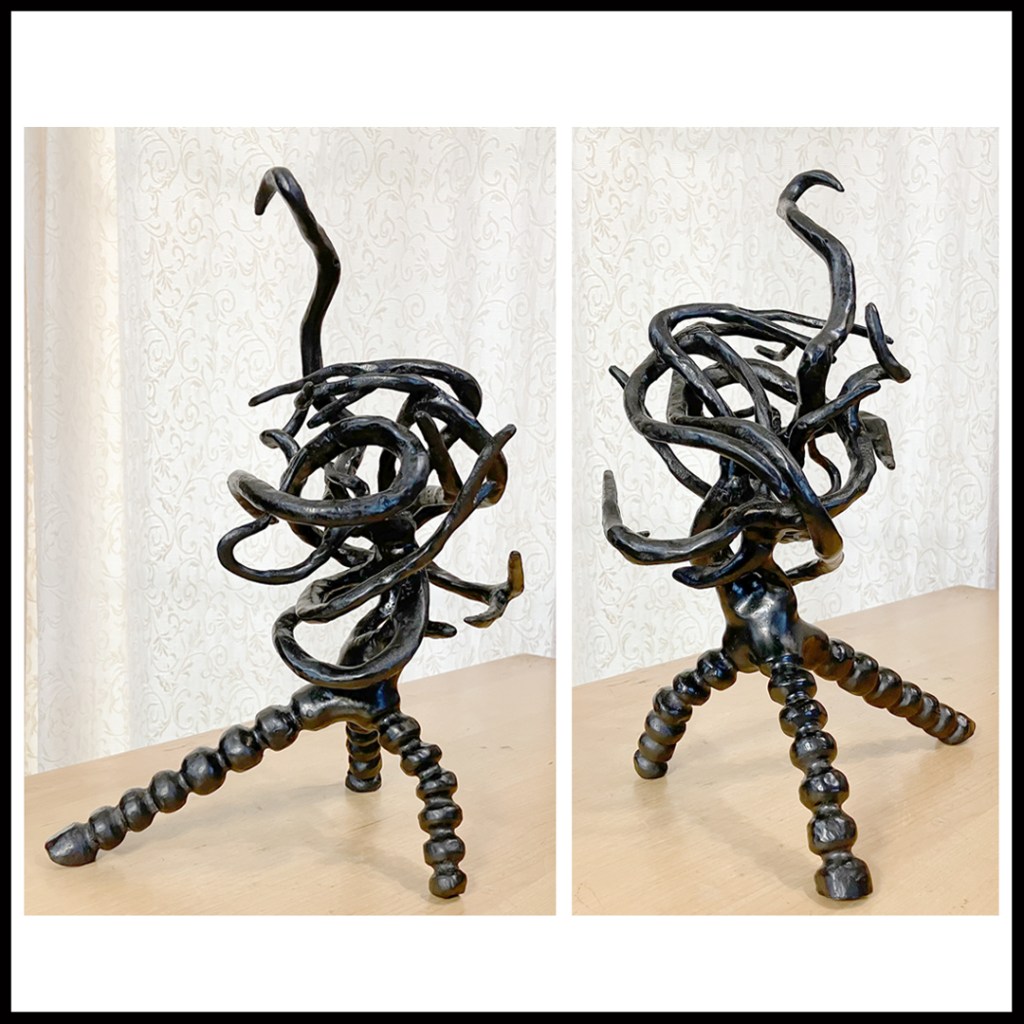 Dark stained wood carving with three point globular legs supporting a convoluted root swirl, one tendril reaching upward, exploring www.SawdustRiver.com